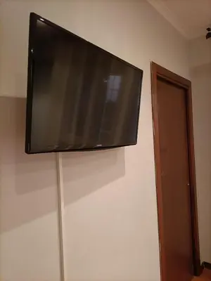 a flat screen tv hanging on a wall at DOMUS VACANZE ROMANE in Rome