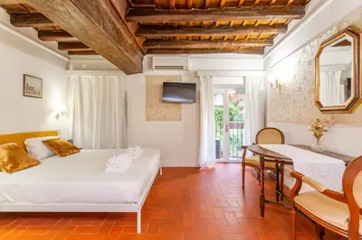 a bedroom with a bed and a table and chairs at Al cortile del Moro in Rome