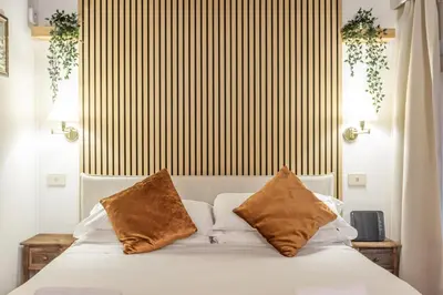 a bedroom with a white bed with two pillows at Al cortile del Moro in Rome