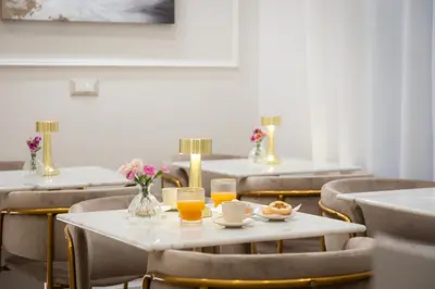 a dining room with tables and chairs with glasses of orange juice at La Dolce Vita Boutique Guest House in Rome