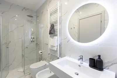 a white bathroom with a sink and a mirror at La Dolce Vita Boutique Guest House in Rome