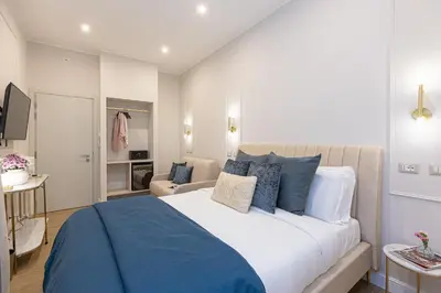 a bedroom with a large bed with blue pillows at La Dolce Vita Boutique Guest House in Rome
