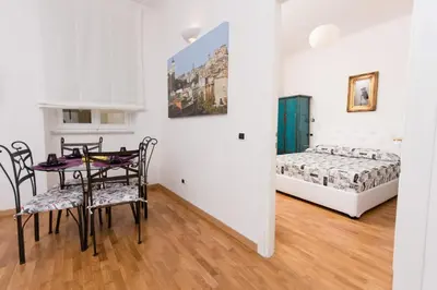 a dining room with a table and chairs and a bed at Baccina Inn in Rome