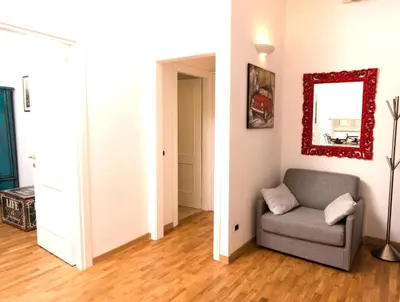 a living room with a chair and a mirror at Baccina Inn in Rome