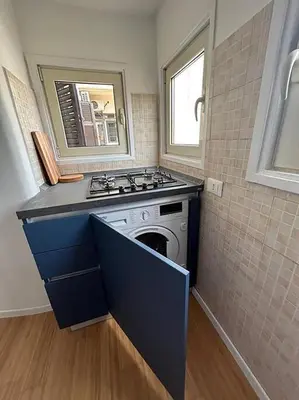 a kitchen with a stove and a sink in it at Manzoni Blue House by GHOR in Rome