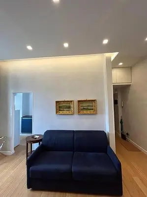 a living room with a blue couch and a table at Manzoni Blue House by GHOR in Rome