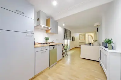 a kitchen with white cabinets and a hardwood floor at Fontanella Borghese CORI apartment in Rome