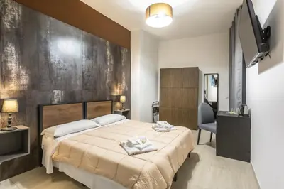 a bedroom with a large bed and a television at Ethnos Relais Vaticano in Rome