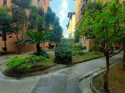 an empty street in a city with trees and buildings at Vaticano Ferrari Apartment in Rome