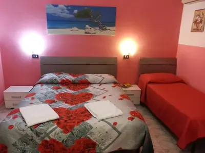 a bedroom with a bed with red flowers on it at Roxena house in Rome