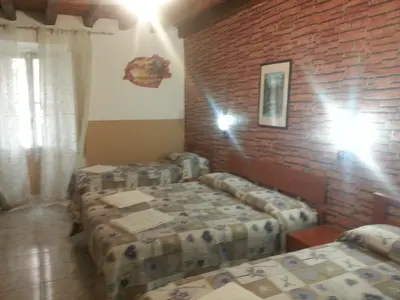 a room with two beds and a brick wall at Roxena house in Rome