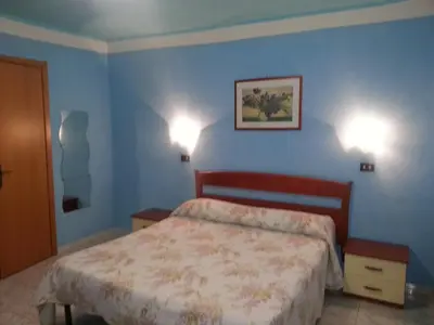 a bedroom with a bed and two lights on the wall at Roxena house in Rome