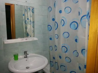 a bathroom with a sink and a shower curtain at Roxena house in Rome