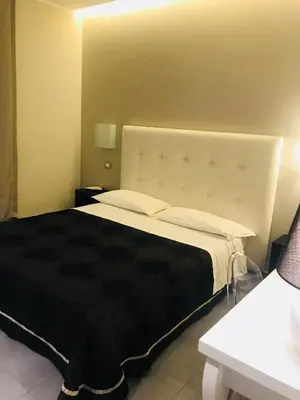 a bedroom with a large bed with a black blanket at Gemini Suite in Rome
