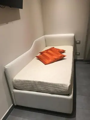a white couch with a pillow on it at Gemini Suite in Rome