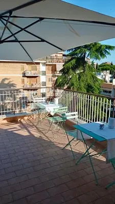 a table and chairs under an umbrella on a patio at Gemini Suite in Rome