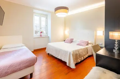 a bedroom with two beds and a couch at Gemini Suite in Rome