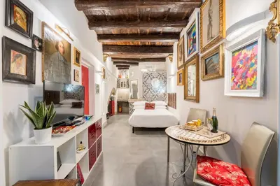a living room with a bed and a table at Intimo ed Eclettico Studio a Trastevere in Rome