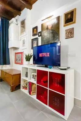 a television on a white entertainment center in a living room at Intimo ed Eclettico Studio a Trastevere in Rome