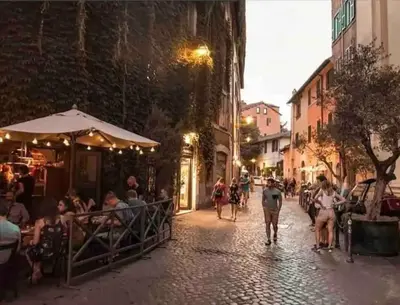 a group of people walking down a street at night at Intimo ed Eclettico Studio a Trastevere in Rome