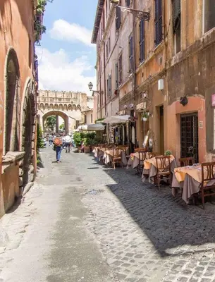 an empty street with tables and chairs in an alley at Intimo ed Eclettico Studio a Trastevere in Rome