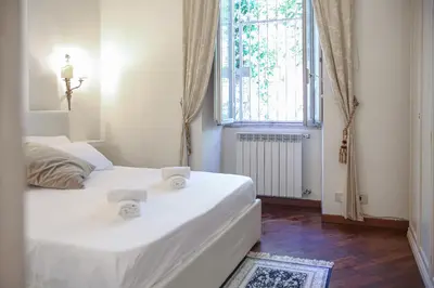 two beds in a small room with a window at Bpremium apartment in Rome