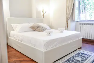 a white bed with two cups on top of it at Bpremium apartment in Rome