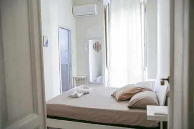 a bed in a white room with a window at Bpremium apartment in Rome
