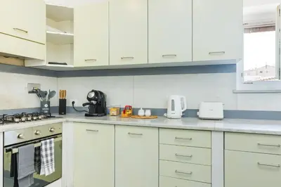a kitchen with white cabinets and a counter top at Nikis Maison Navona - 4th floor no elevator in Rome
