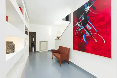 a hallway with a chair and a painting on the wall at Nikis Maison Navona - 4th floor no elevator in Rome