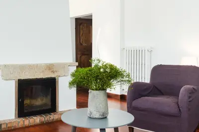a living room with a chair and a vase on a table at Nikis Maison Navona - 4th floor no elevator in Rome