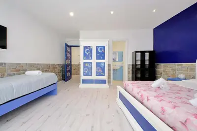 a bedroom with two beds and a blue and white wall at Lucky Domus Appio in Rome