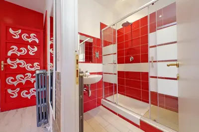 a bathroom with red and white tiles and a sink at Lucky Domus Appio in Rome