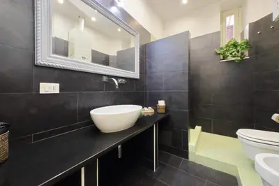 a black bathroom with a sink and a toilet at Flatinrome Trastevere 2 - Jacuzzi in Trastevere in Rome