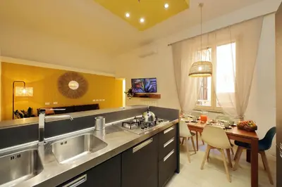 a kitchen with a sink and a dining room with a table at Flatinrome Trastevere 2 - Jacuzzi in Trastevere in Rome