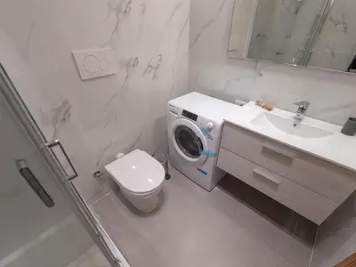 a bathroom with a washing machine next to a toilet at Spanish Steps, Suite Dominic, Strollingrome in Rome