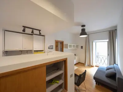 a kitchen with a counter and a living room at Spanish Steps, Suite Dominic, Strollingrome in Rome