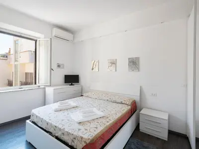 a white bedroom with a bed and a window at Apartment Pratolina by Interhome in Rome