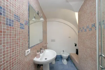 a bathroom with a sink and a mirror and a toilet at Colosseo Family Apartment Capo d'Africa AC/wifi in Rome