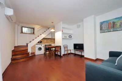 a living room with a staircase and a dining room at Colosseo Family Apartment Capo d'Africa AC/wifi in Rome