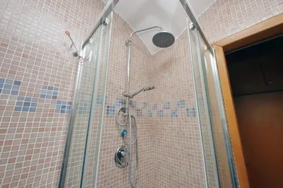 a shower in a bathroom with pink tiles at Colosseo Family Apartment Capo d'Africa AC/wifi in Rome