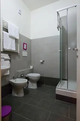 a bathroom with a toilet and a glass shower at Madì B&B in Rome