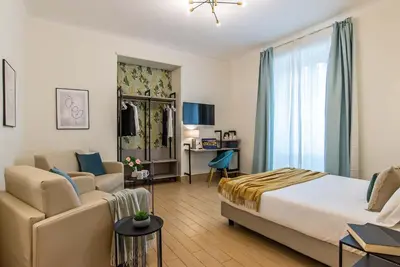 a hotel room with a bed and a couch at 94Rooms Vatican Guest House - Vigliena in Rome