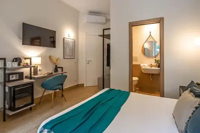 a bedroom with a bed and a desk and a sink at 94Rooms Vatican Guest House - Vigliena in Rome