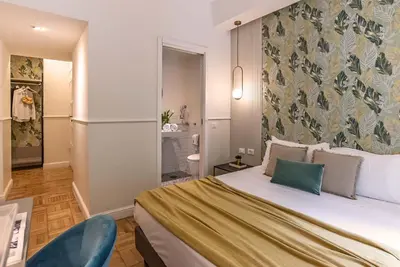 a bedroom with a large bed and a bathroom at 94Rooms Vatican Guest House - Vigliena in Rome
