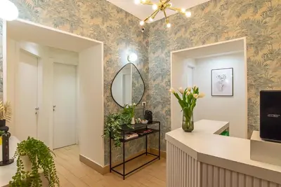 a dressing room with a mirror and flowers on the wall at 94Rooms Vatican Guest House - Vigliena in Rome