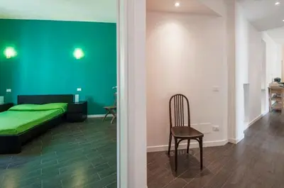 a bedroom with a green bed and a chair at Bed & Puppets in Rome