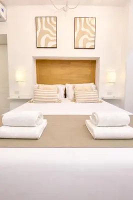 two beds with white sheets and pillows in a bedroom at “Suite Home Vaticano City” in Rome
