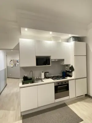 a kitchen with white cabinets and a stove at “Suite Home Vaticano City” in Rome