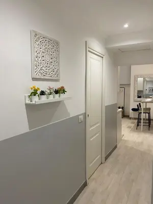 a white hallway with two plants on a shelf at “Suite Home Vaticano City” in Rome